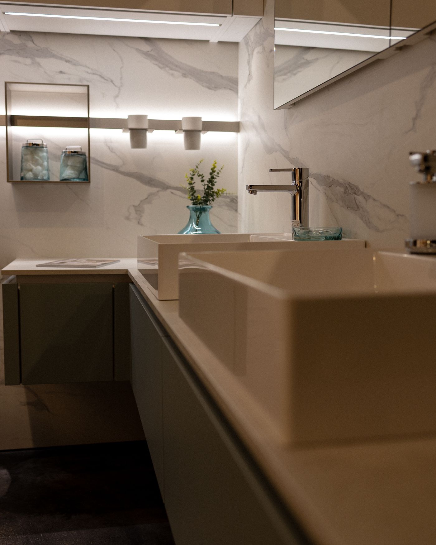 Marble bathroom with long vanity and warm lighting