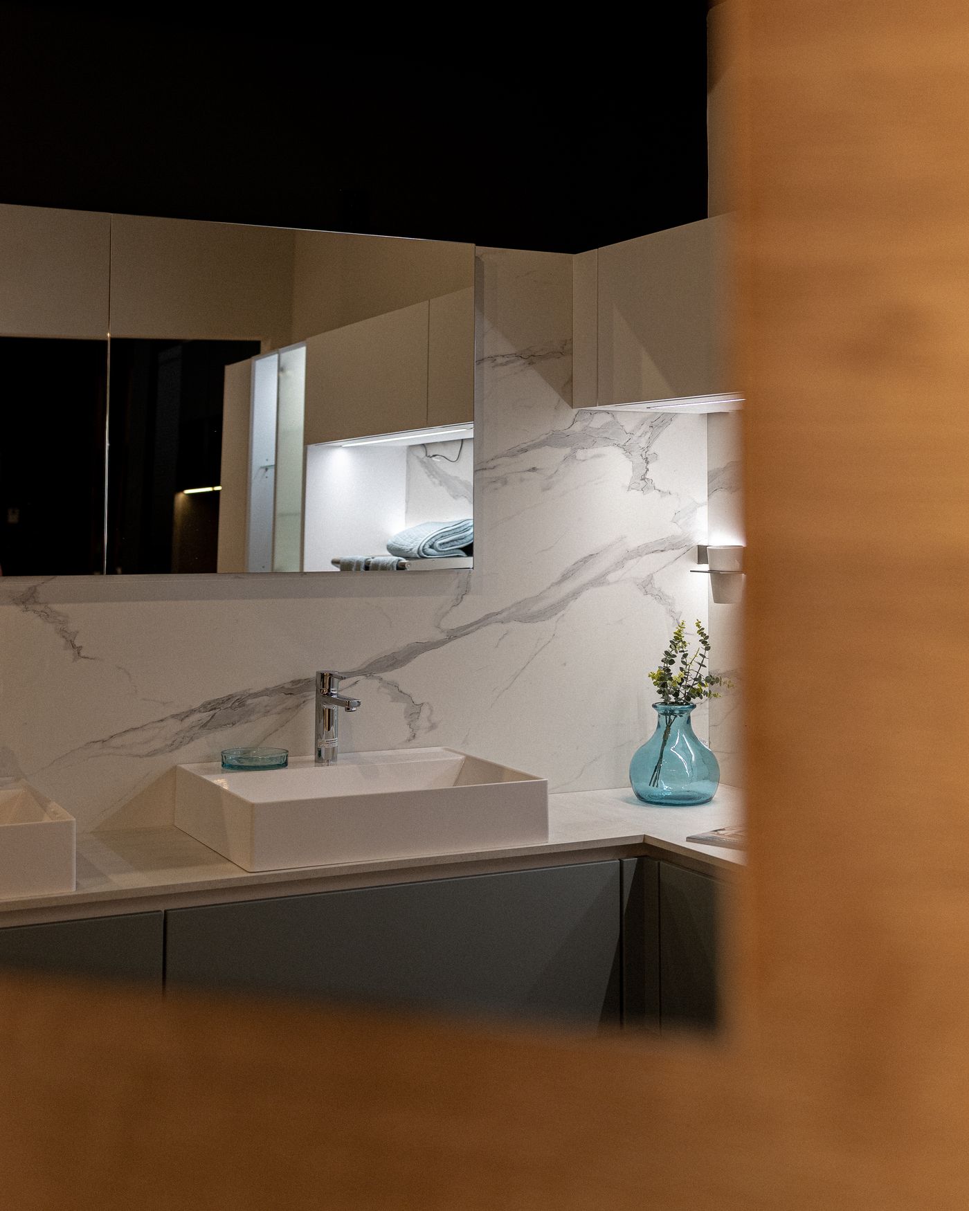 Marble bathroom vanity framed by a wood doorway