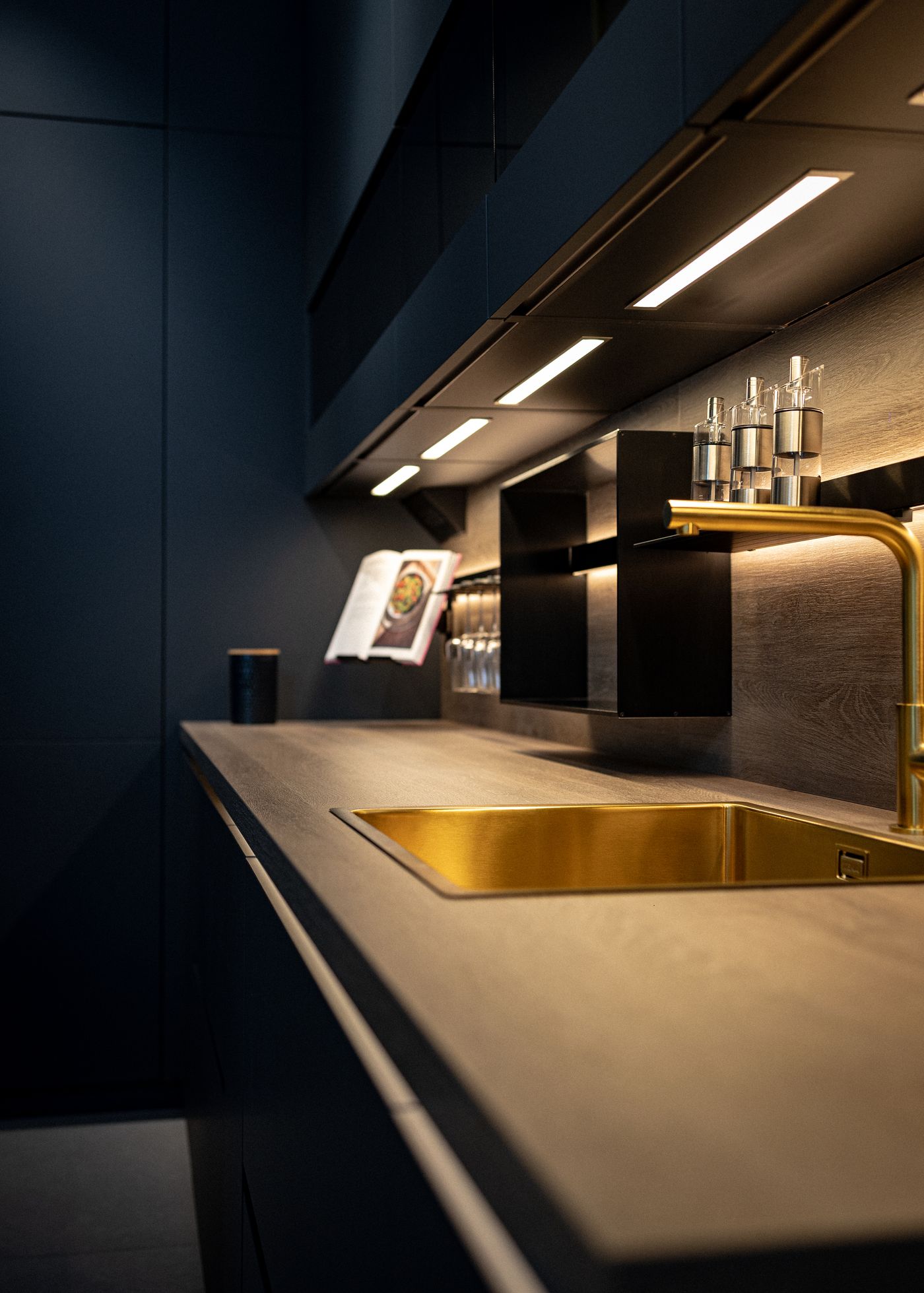 Black kitchen with brass sink and fittings